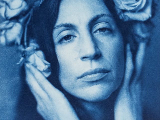 This is a cyanotype of a woman with flowers in her hair.