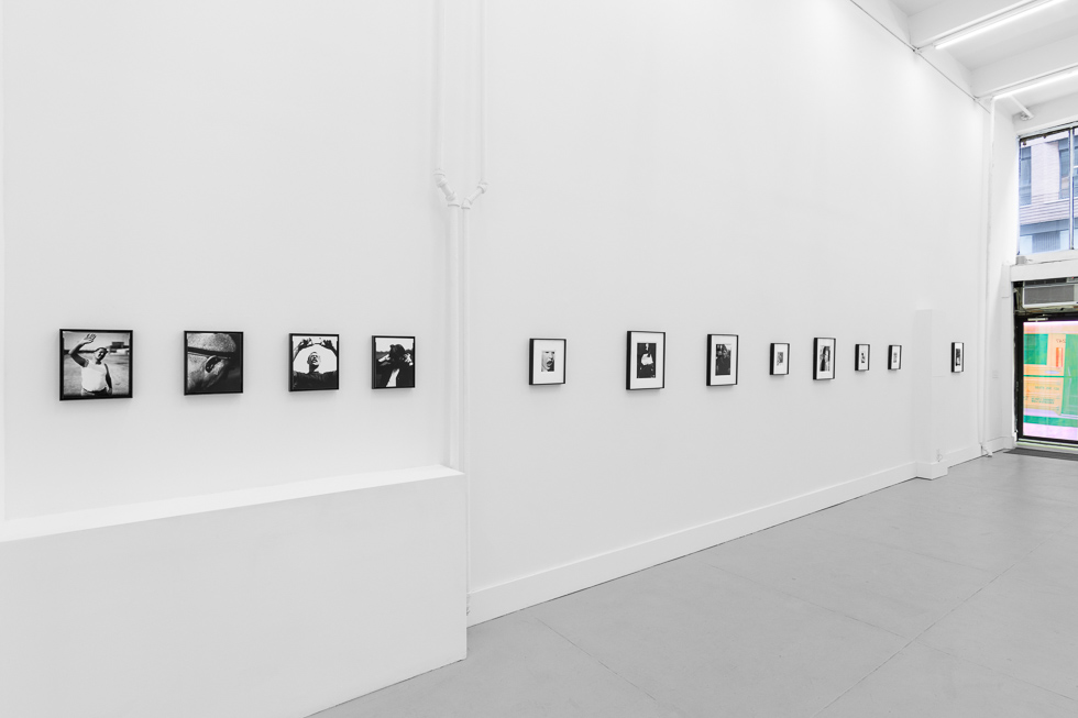 This is a photograph of black and white framed images on display in a minimalistic gallery setting.