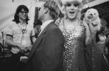 This is a black and white photograph of a person in a sequined gown smiling at the camera backstage.