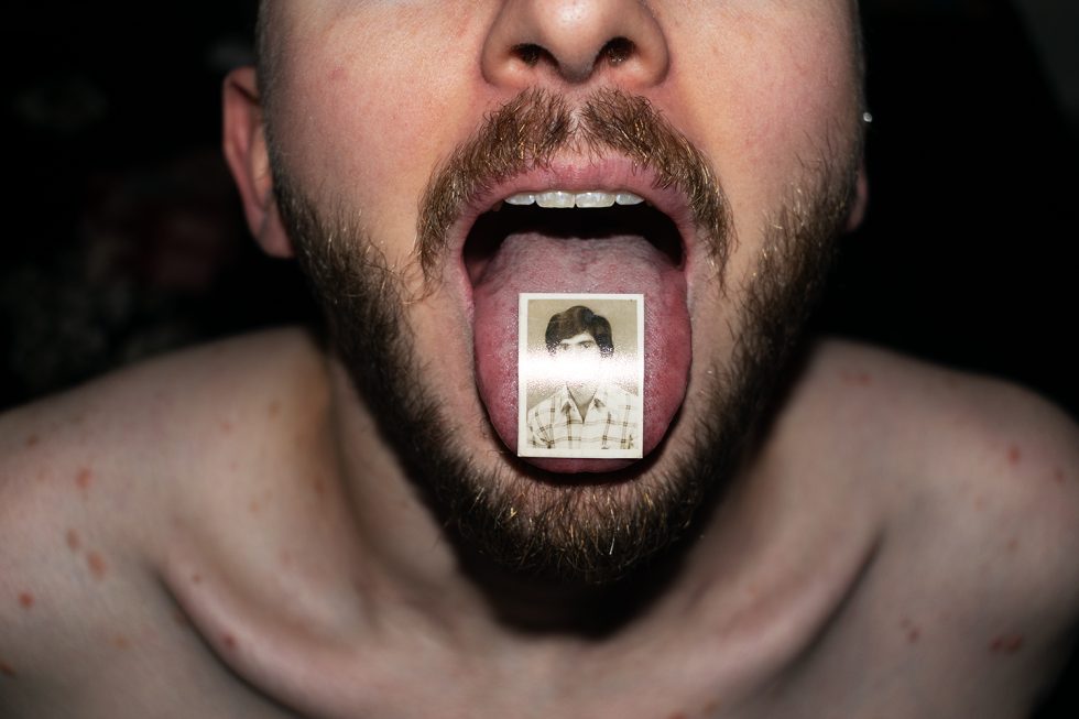 This is a photograph of a man's tongue with a small photograph on it.