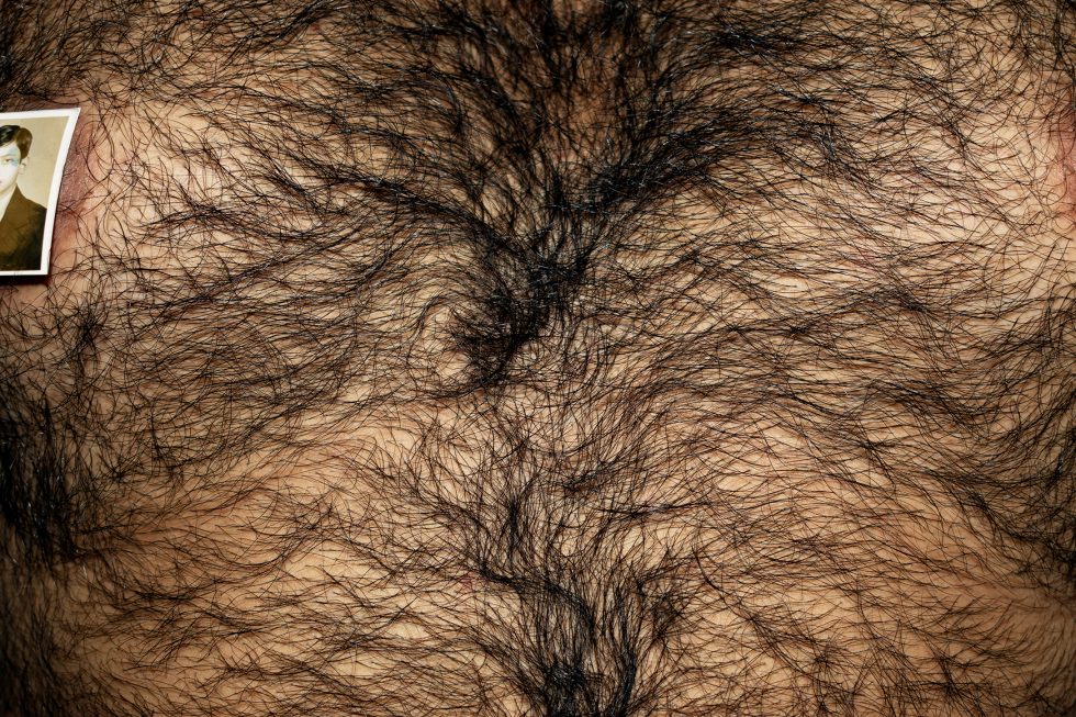This is a color photograph of a hairy chest with a photograph on it.