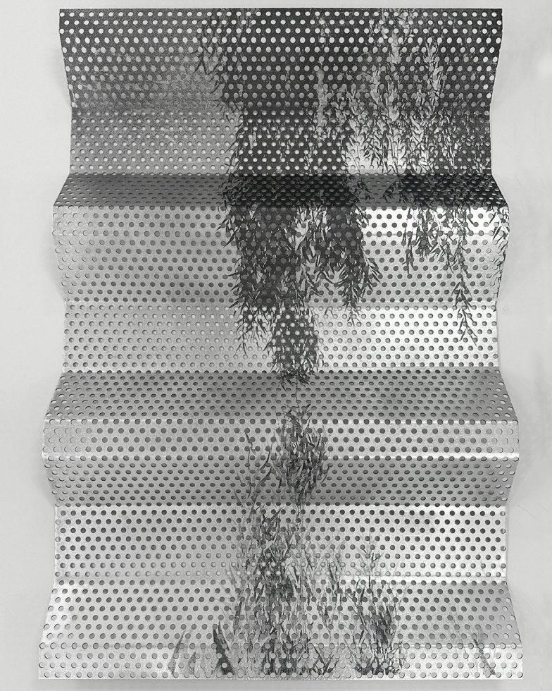 This is a photograph of a piece of metal with a willow tree on it.