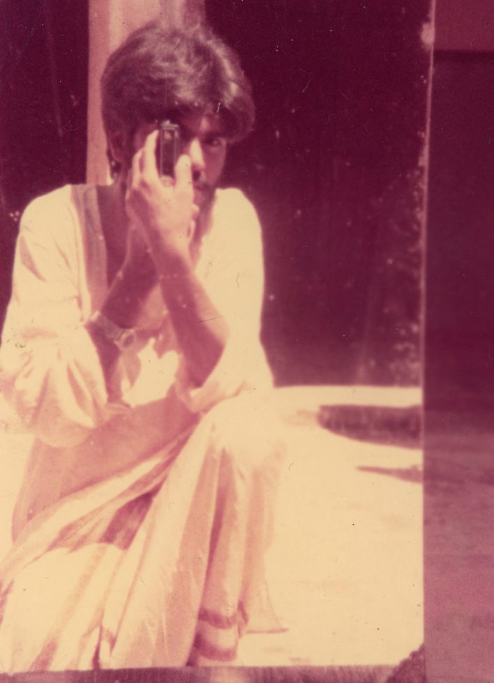 This is a color caste image of a man holding a camera.
