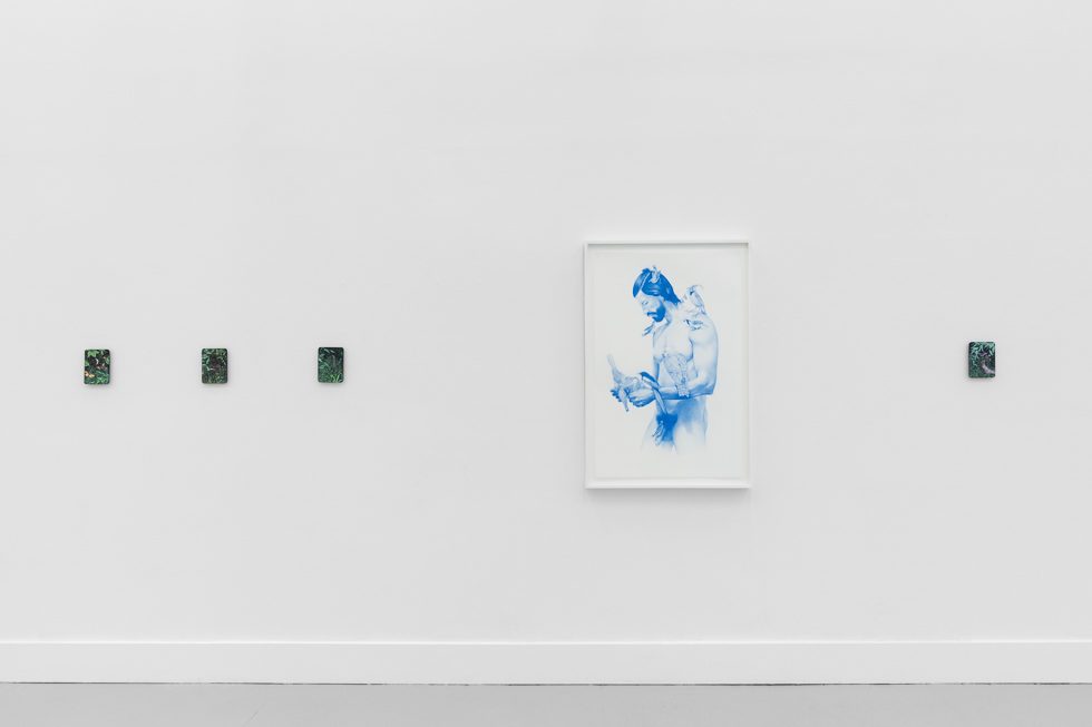 A minimalist gallery installation with small, framed artworks in soft blue hues, arranged on a stark white wall in an open, airy space.