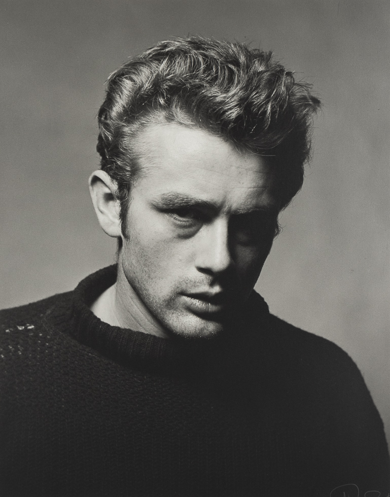 A black and white photograph of James Dean looking off to the side in a studio setting.