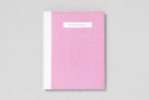 A pink book on a grey background.