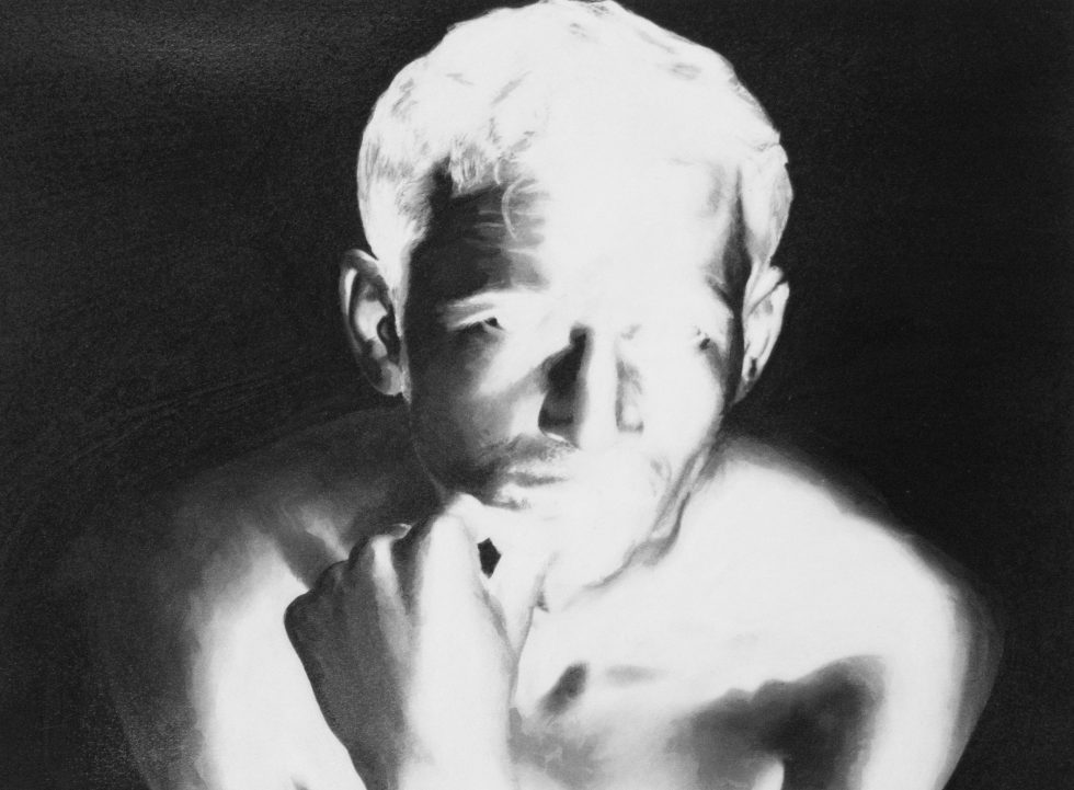 A black and white photograph of a man's upper torso and face as a high contrast negative.