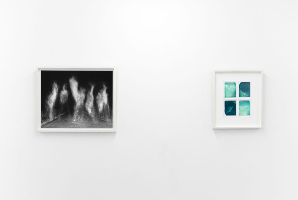 An installation view in a bright, white-walled contemporary art gallery.