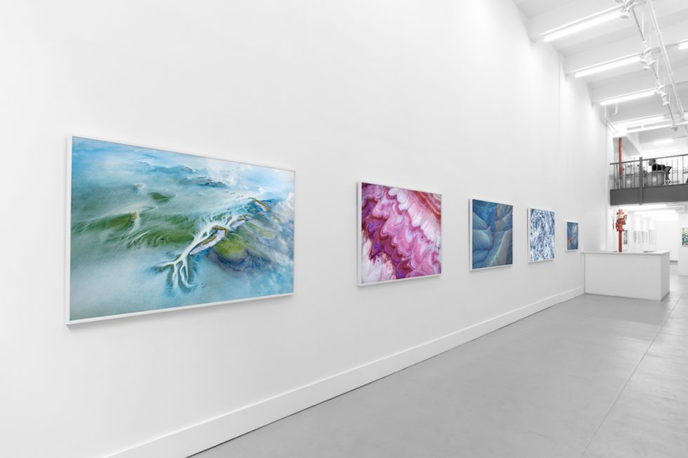 An installation image of a contemporary photography exhibition in a white-walled gallery.