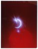 A crescent moon glows with a bright flare against a deep red sky speckled with tiny stars.