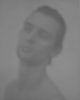 A blurry black and white image of a young man's face.