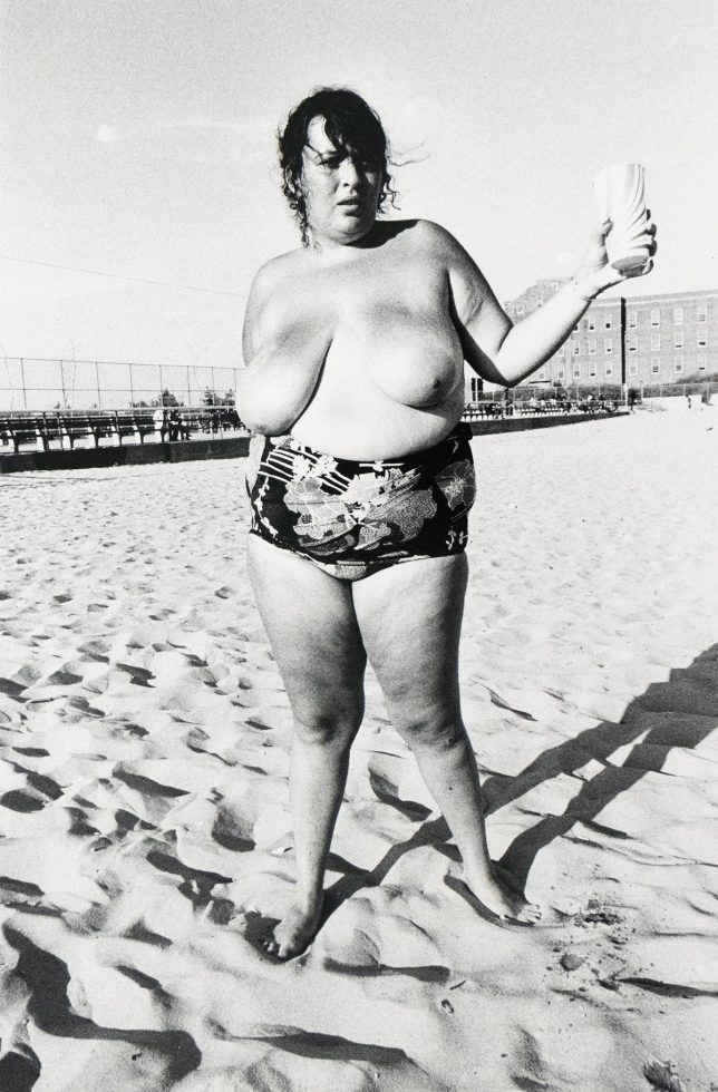 Topless Large Woman on Beach Holding Can by Arlene Gottfried