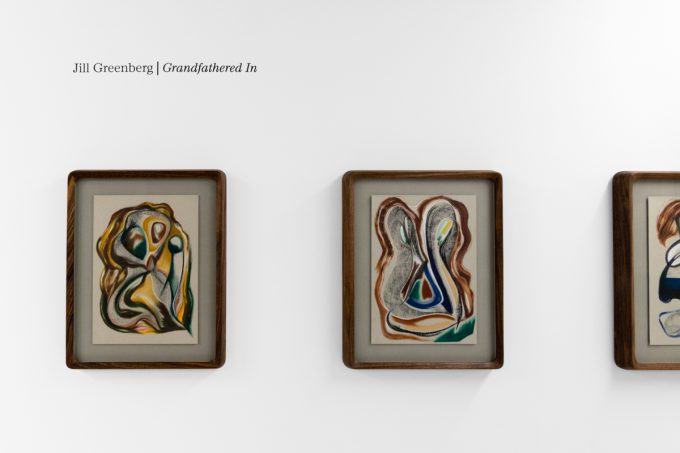 A series of abstract framed drawings hang on a white gallery wall under a black and white artist name and exhibition title.