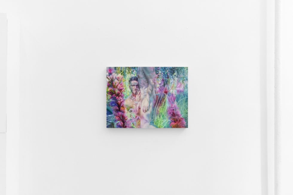 A vibrant painting shows a semi-nude figure among lush, surreal plants in shades of pink, green, and purple on a white gallery wall.