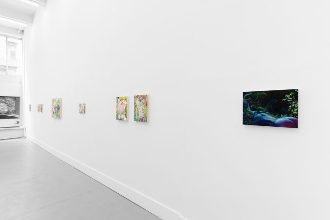 Colorful artworks on a bright white gallery wall in neutral lighting.