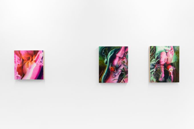 Colorful artworks on a bright white gallery wall in neutral lighting.