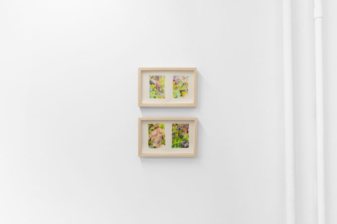 Colorful artworks on a bright white gallery wall in neutral lighting.