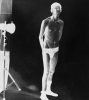 A black and white drawing of a man standing in a photo studio