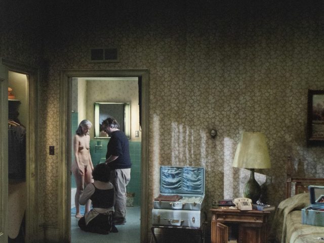A photograph of 3 people in a bathroom.