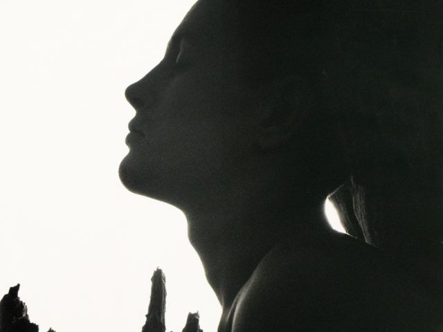 Silhouetted profile of a man with closed eyes, framed by jagged shadows and a stark white background.