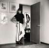 Person posing confidently in a room decorated with bold artwork and fashion illustrations.