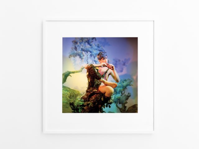 Brightly lit gallery with colorful, surreal portraits in white frames displayed along stark white walls.