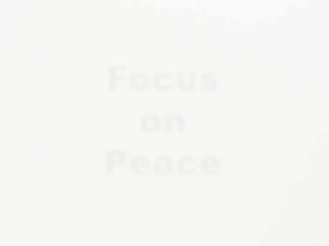 A stark white image features the faint, barely visible word "Focus on Peace" in the center, hinting at a minimalist conceptual piece.