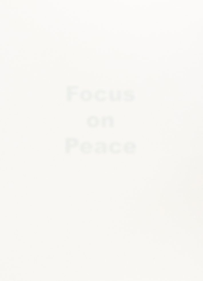 A stark white image features the faint, barely visible word "Focus on Peace" in the center, hinting at a minimalist conceptual piece.