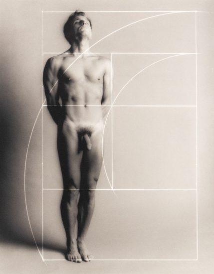 Nude man stands upright with eyes closed, overlaid by a white Fibonacci spiral and golden ratio grid on a soft gray background.
