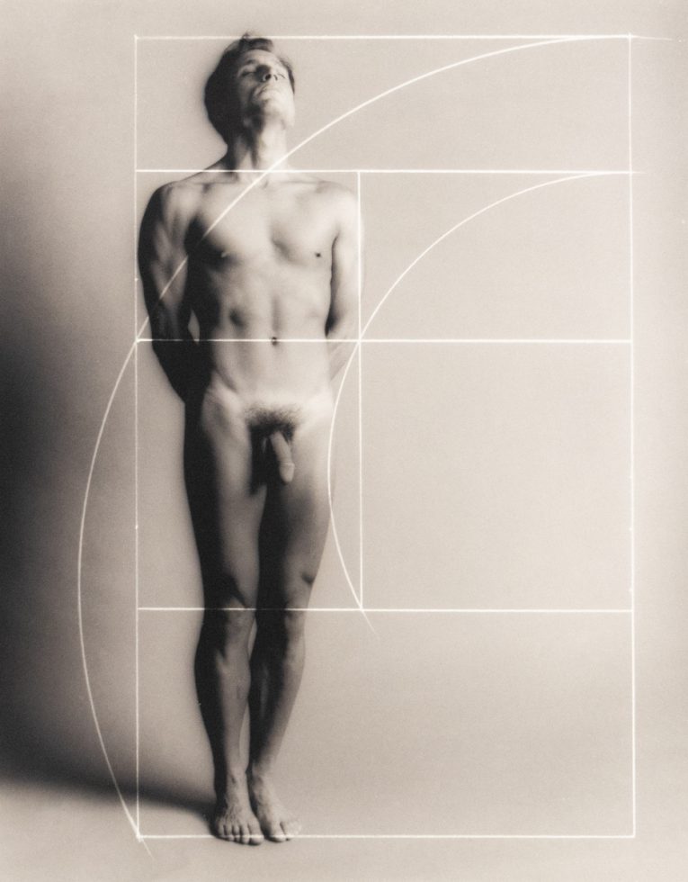 Nude man stands upright with eyes closed, overlaid by a white Fibonacci spiral and golden ratio grid on a soft gray background.