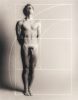 Nude man stands upright with eyes closed, overlaid by a white Fibonacci spiral and golden ratio grid on a soft gray background.