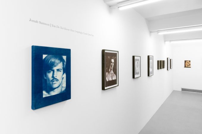 Contemporary artworks displayed along stark white bright gallery walls.