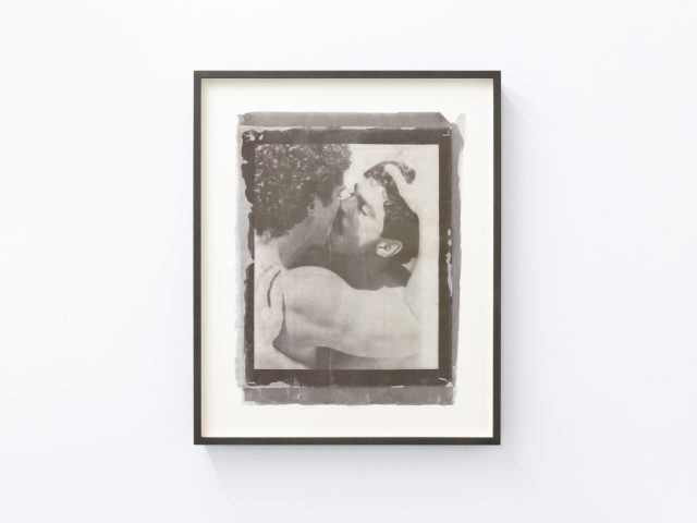 Contemporary artworks displayed along stark white bright gallery walls.