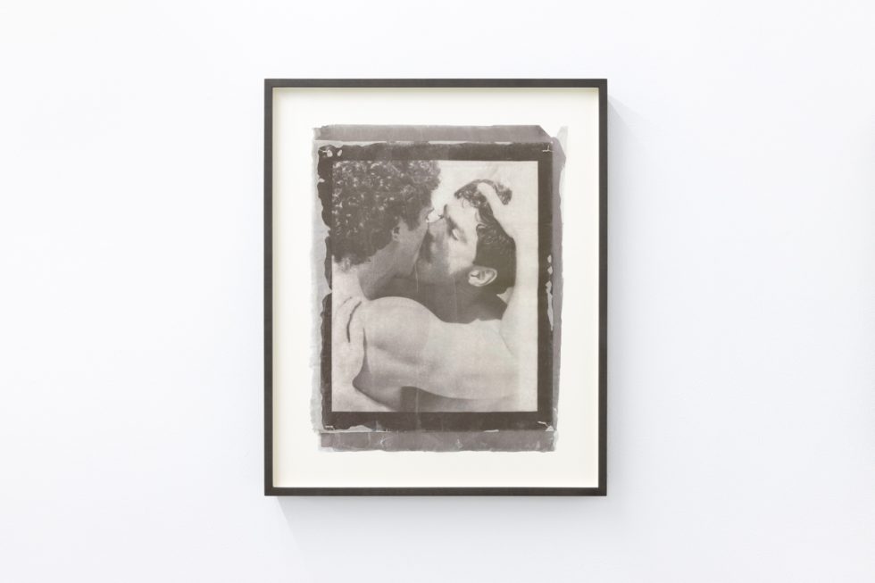 Contemporary artworks displayed along stark white bright gallery walls.