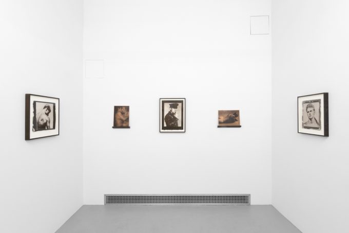 Contemporary artworks displayed along stark white bright gallery walls.