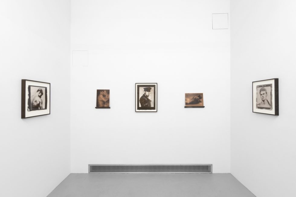 Contemporary artworks displayed along stark white bright gallery walls.