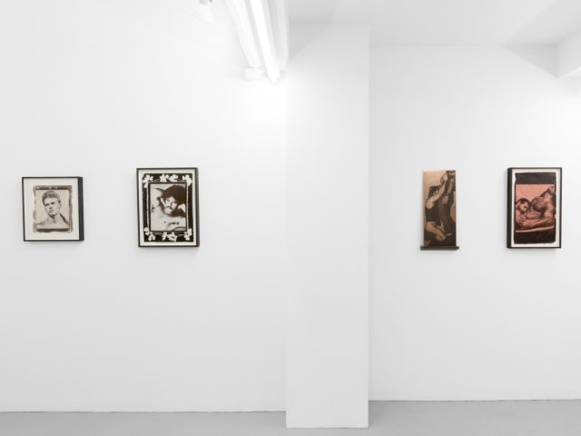 Contemporary artworks displayed along stark white bright gallery walls.