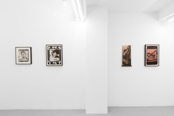 Contemporary artworks displayed along stark white bright gallery walls.