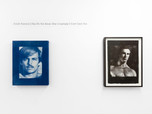Contemporary artworks displayed along stark white bright gallery walls.