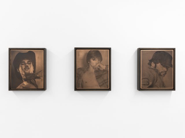 Contemporary artworks displayed along stark white bright gallery walls.
