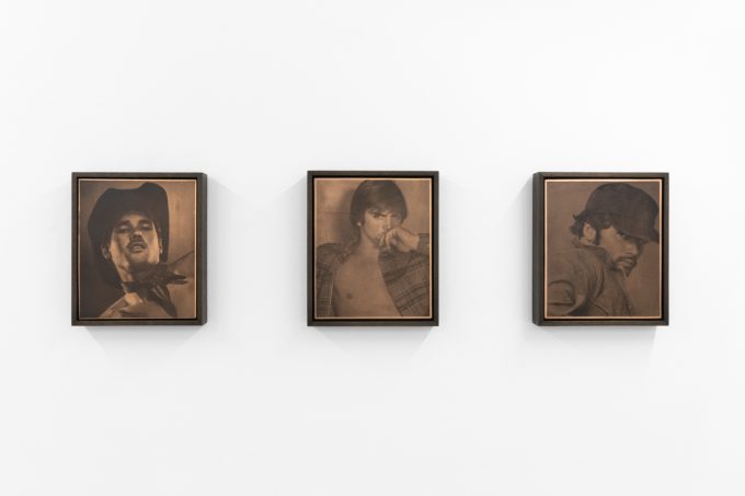 Contemporary artworks displayed along stark white bright gallery walls.
