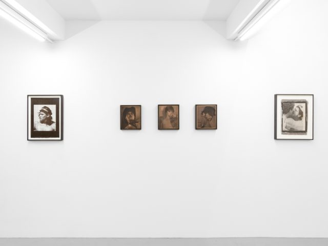 Contemporary artworks displayed along stark white bright gallery walls.