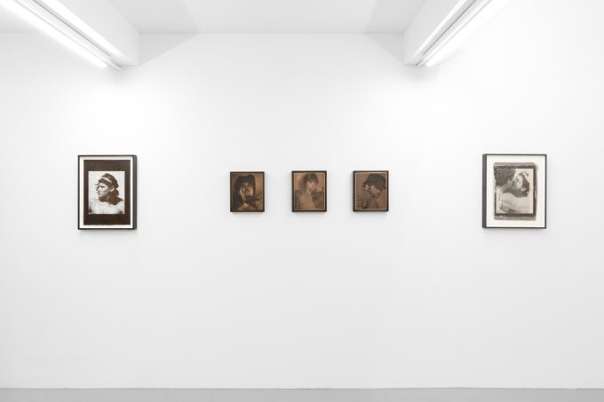 Contemporary artworks displayed along stark white bright gallery walls.