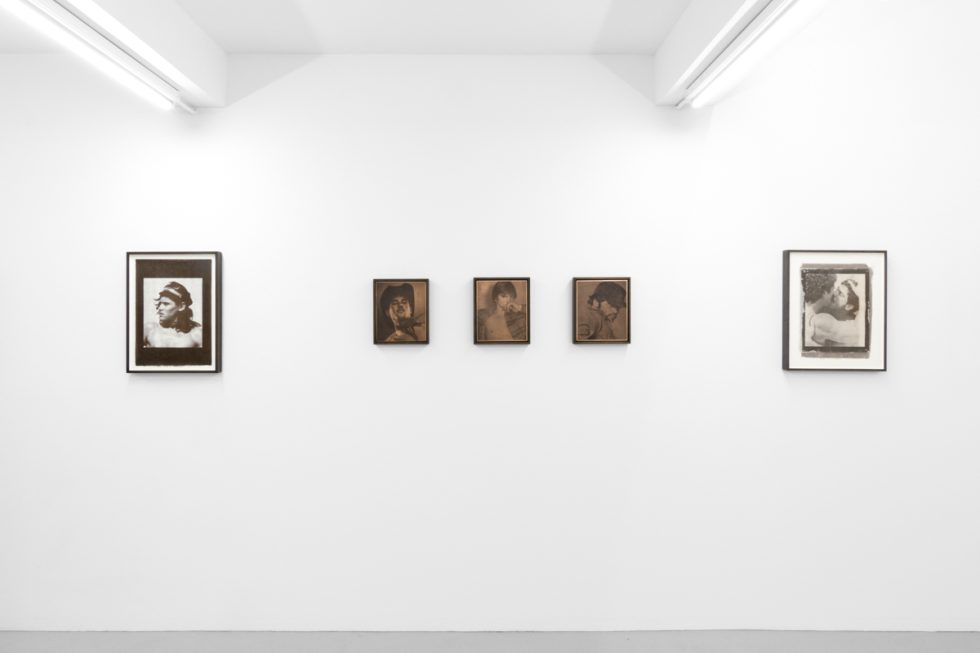 Contemporary artworks displayed along stark white bright gallery walls.
