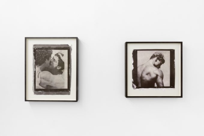 Contemporary artworks displayed along stark white bright gallery walls.