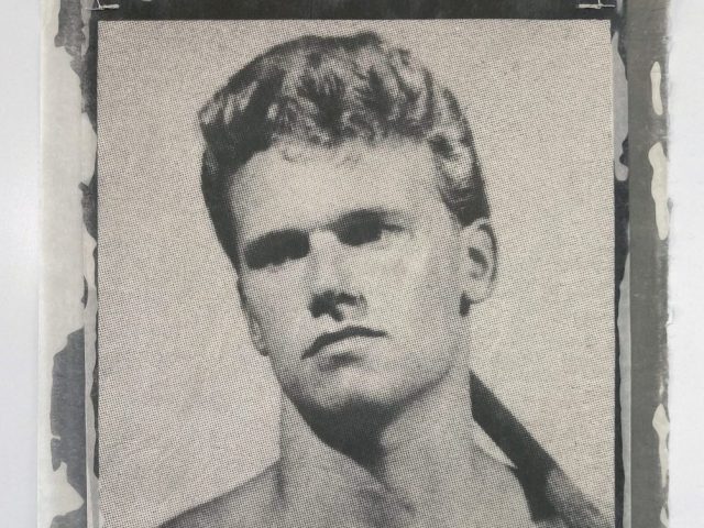 This close-up, black and white portrait features a young man with light hair and serious eyes, his image rendered on what appears to be a textured fabric or paper.