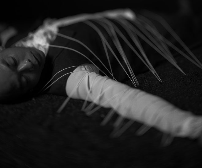 A black and white photograph of a person lying on their back.
