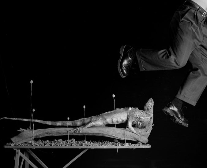 A black and white photograph of a man leaping through the air.