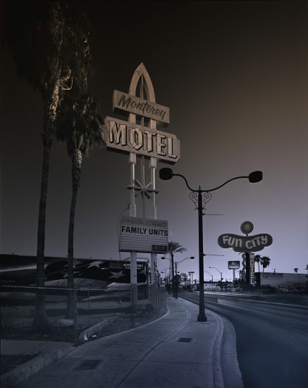 A photograph of a towering motel sign that says "Monterey Hotel"