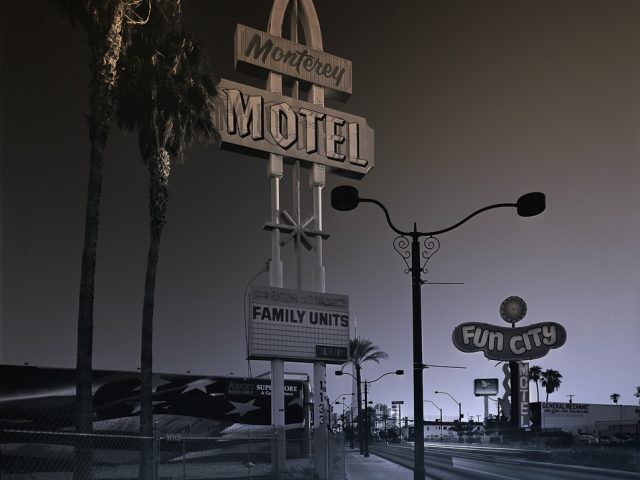A photograph of a towering motel sign that says "Monterey Hotel"